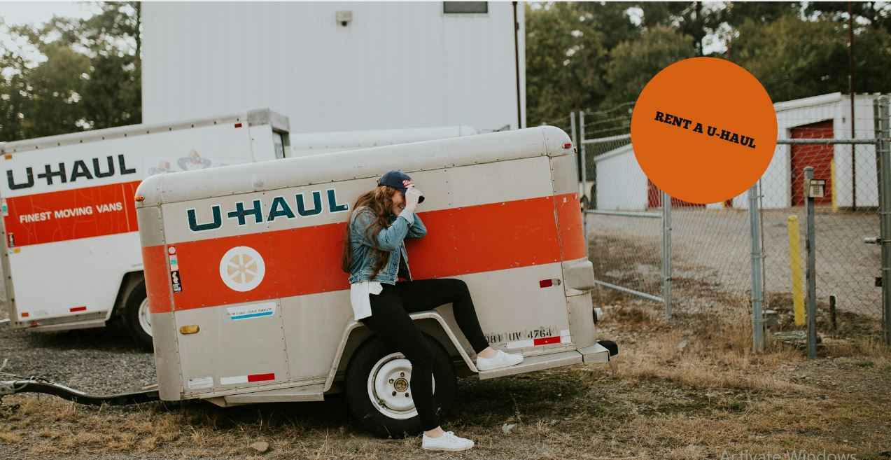 a girl is sitting on U-HAUL truck
